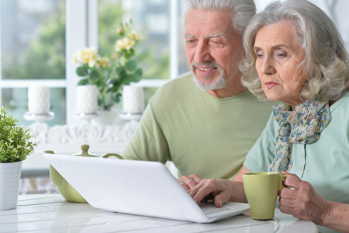 happy senior couple with laptop